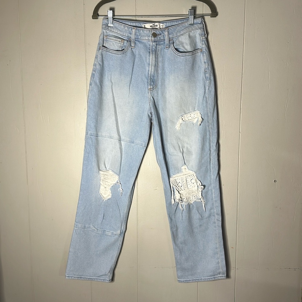 These jeans are in good condition and have a flower pattern on the rips.